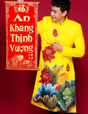 Áo dài nam vàng nổi bật với hoa sen đỏ